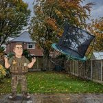 Keith watches his trampoline blow over the fence during Storm Austen, in a UK back garden in wind and rain